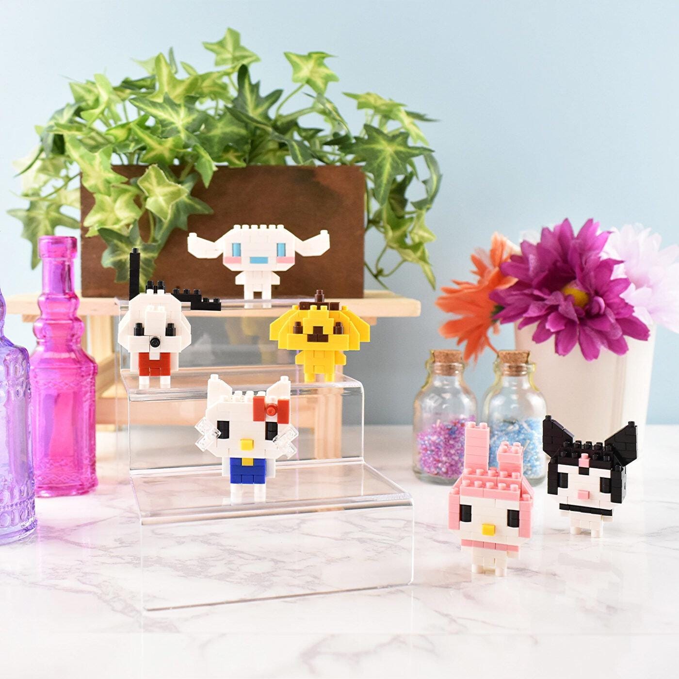 a collection of colorful, pixelated character figurines displayed on a marble countertop, surrounded by various decorative elements such as potted plants, vases, and bottles.