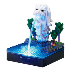 A miniature Lego sculpture depicting a fountain with a water spout, surrounded by trees and other Lego elements.