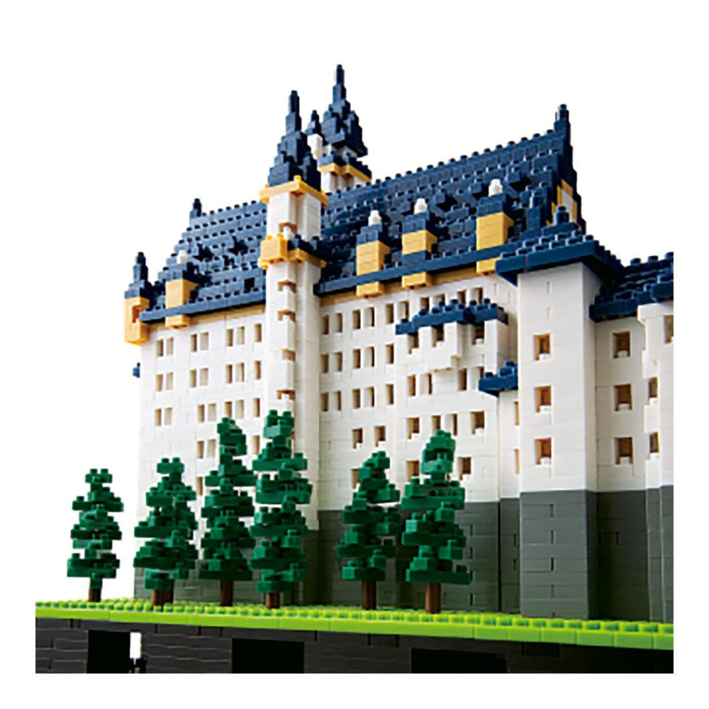 A detailed model of a castle-like building constructed from small, colorful building blocks, resembling a Lego or similar construction toy.