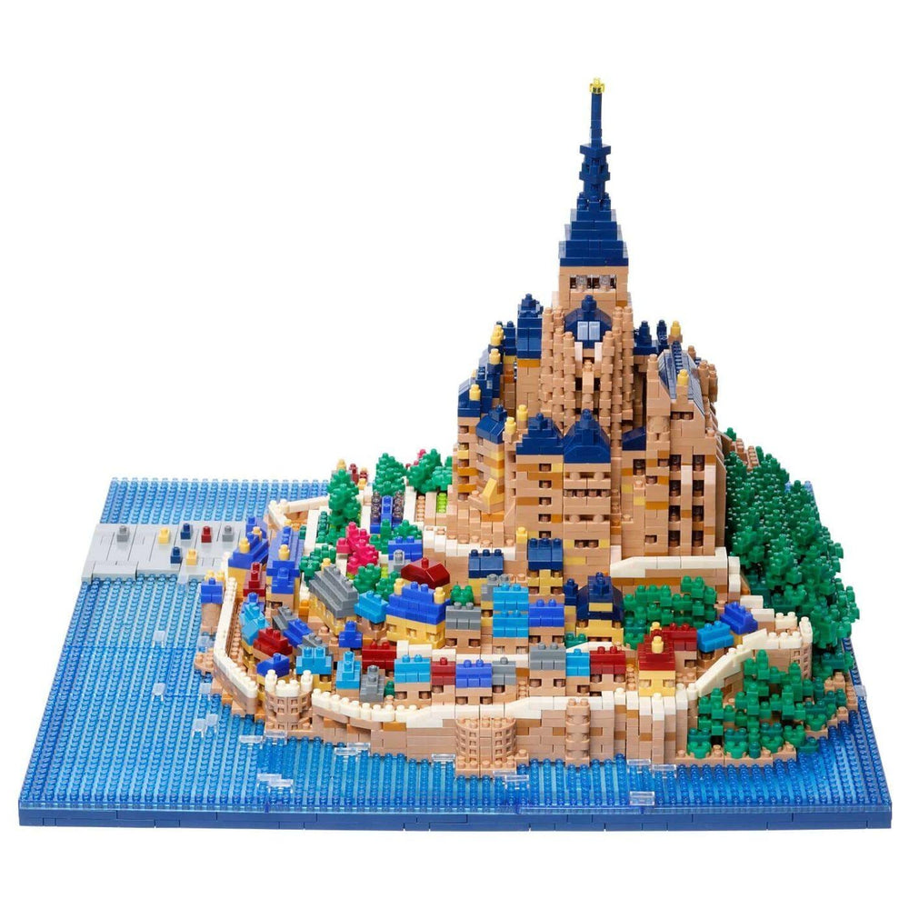 A detailed and colorful model of a castle or palace, constructed from small building blocks, set against a backdrop of water and greenery.