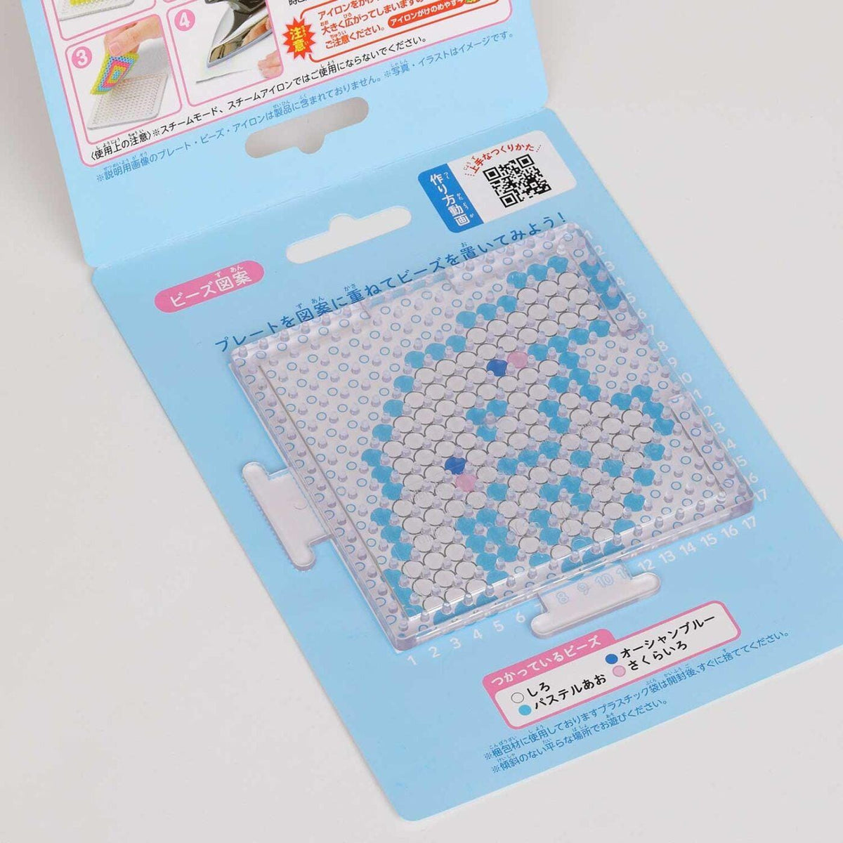a clear plastic container with a pattern of blue and white dots, resembling a mosaic or a pattern. The container appears to be a craft or art item, possibly used for creating designs or patterns.