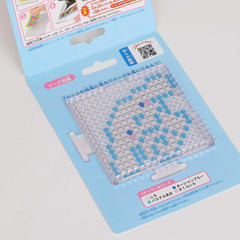 a clear plastic container with a pattern of blue and white dots, resembling a mosaic or a pattern. The container appears to be a craft or art item, possibly used for creating designs or patterns.
