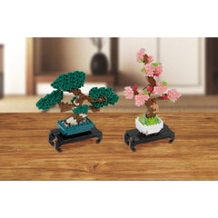 Two assembled bonsai trees in nano building blocks: pink blossoms and green leaves, on stands