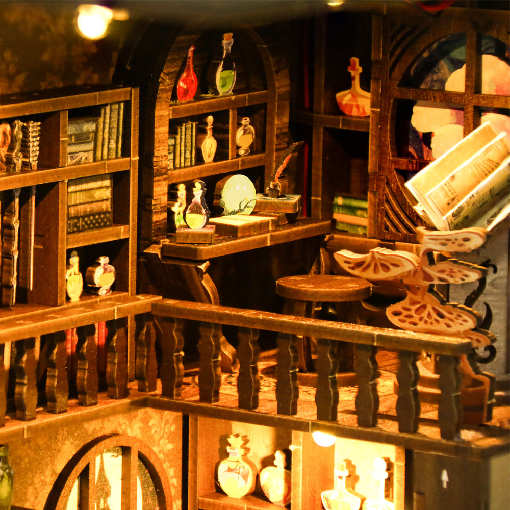 Wooden book nook diorama with shelves, potion bottles, and lit candle holders