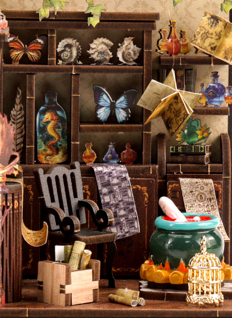 Close-up of DIY miniature house kit interior shelves with bottles, butterfly decor, and chairs