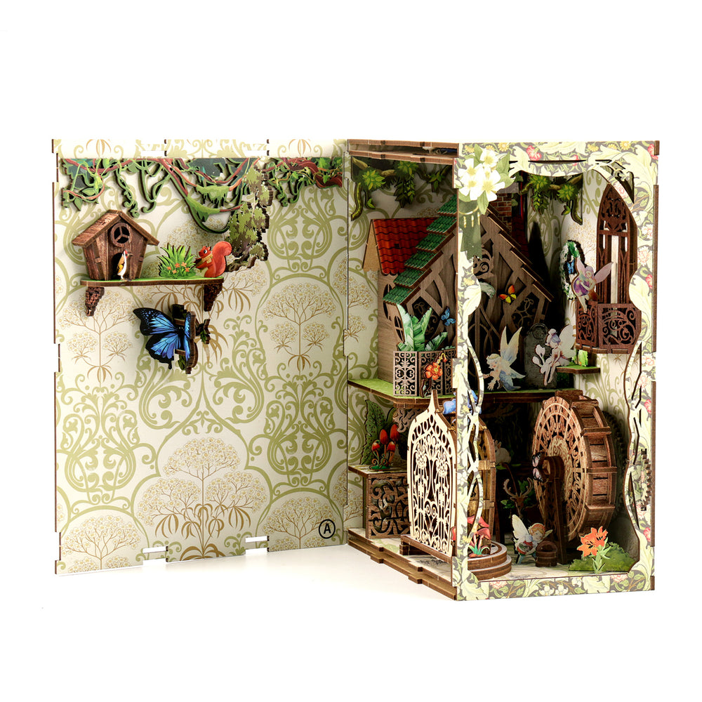 DIY book nook kit box opened to reveal interior forest room with lanterns and figures