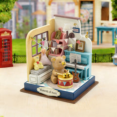 Miniature music room craft kit with teddy bear, piano, and drum on display