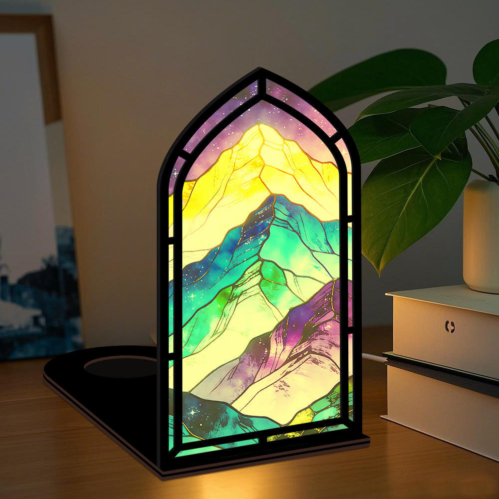 Arched glowing mountain book nook panel with colorful LED border on tabletop