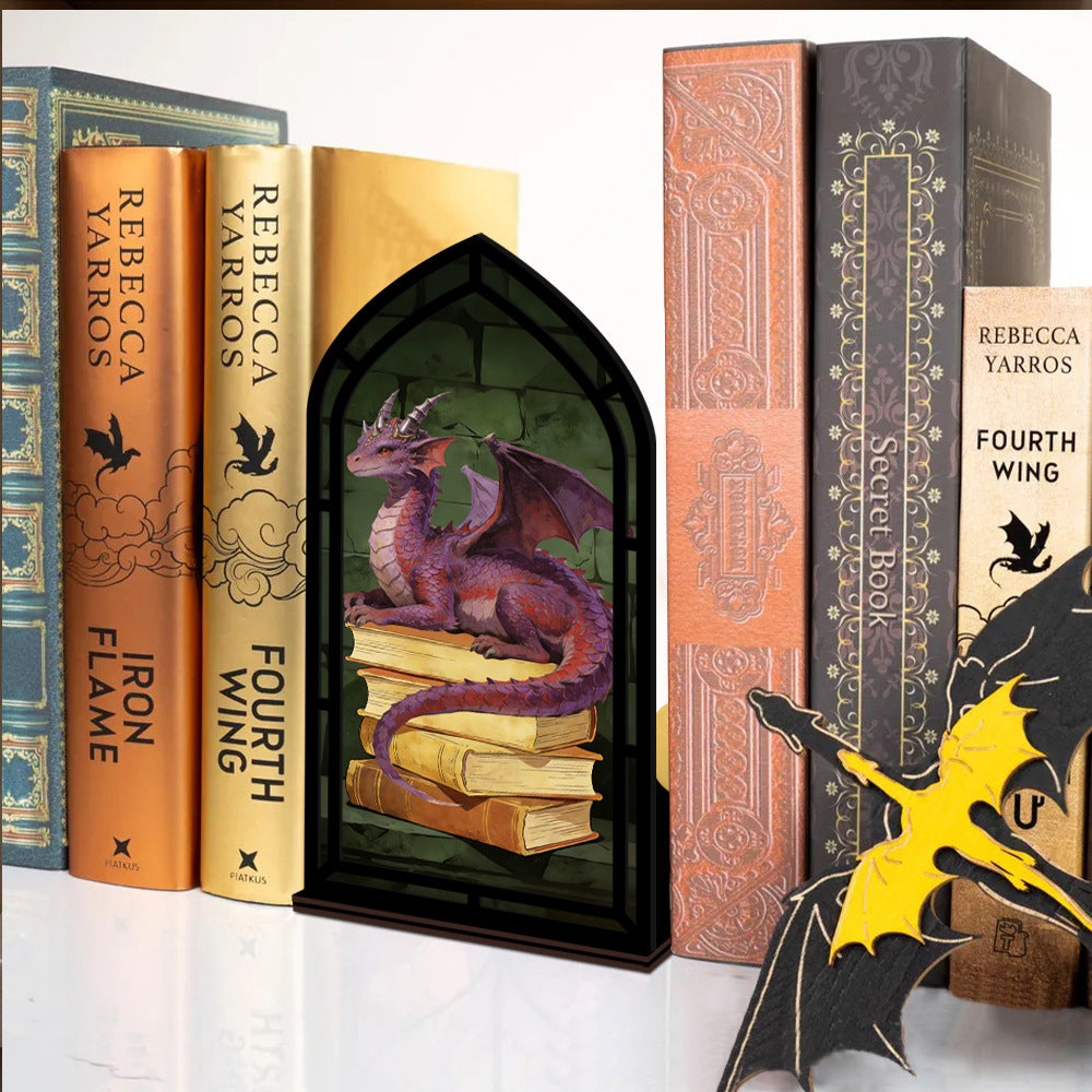 Dragon book nook with candle glow: arched black frame showing purple dragon on stacked books