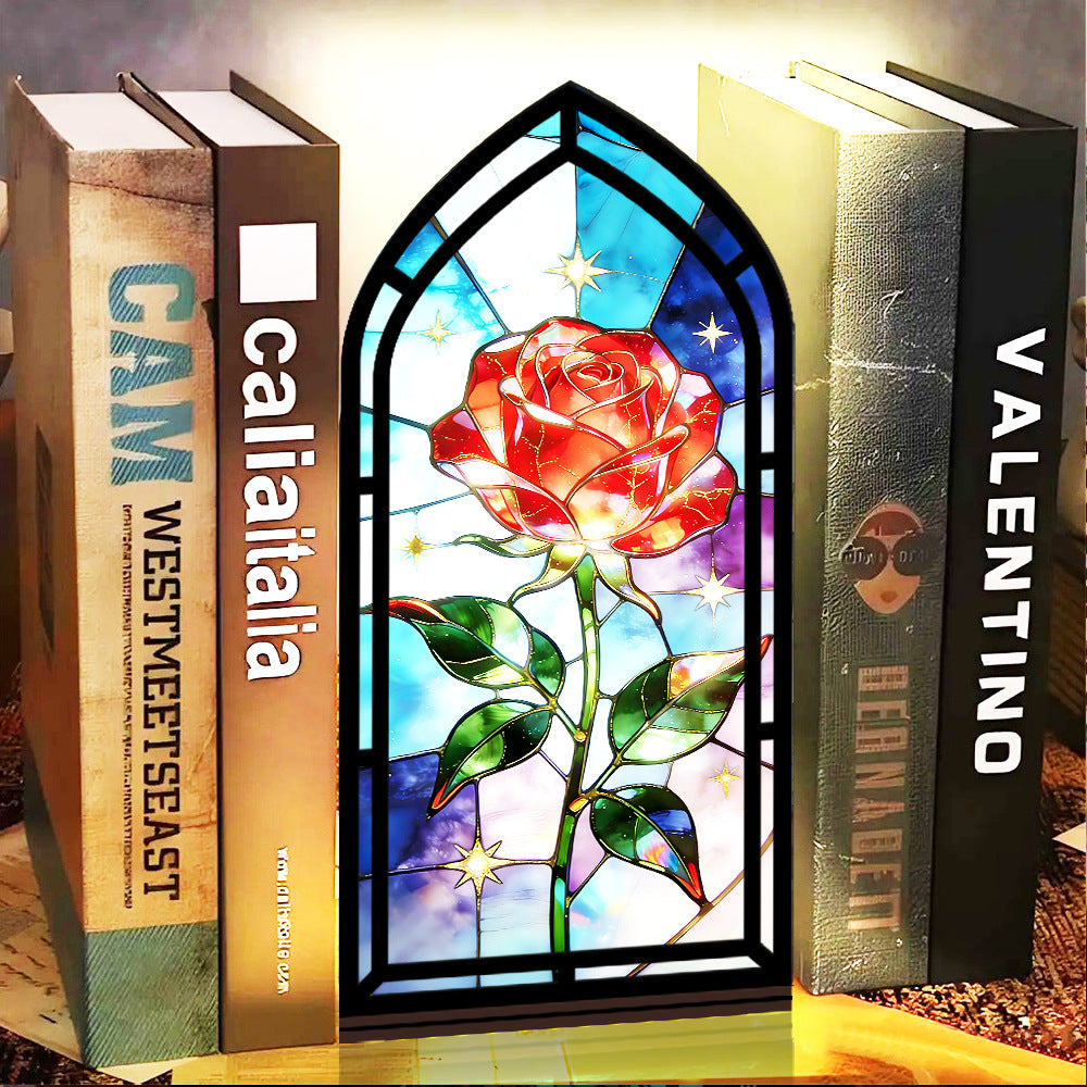 Black arched book nook with stained-glass red rose and starry background, candle glow