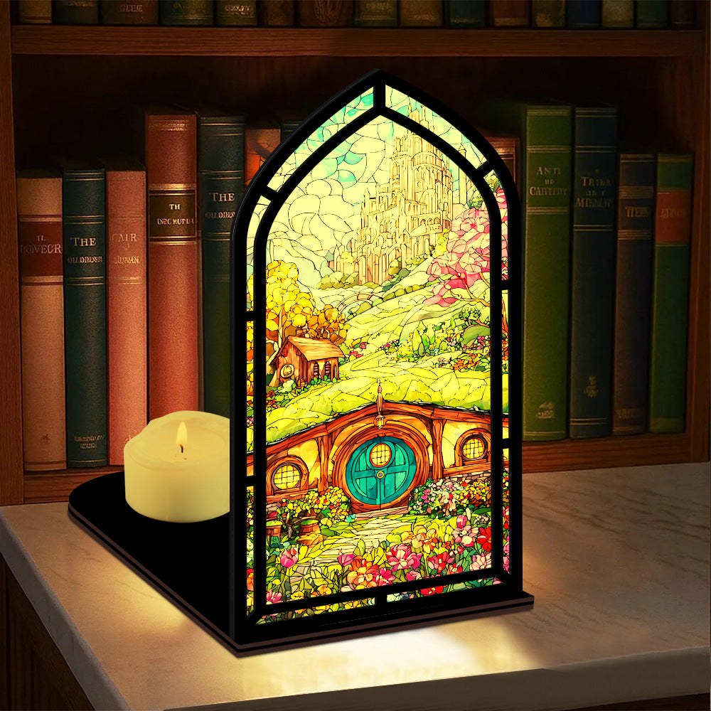 Arched book nook display with colorful illustrated panel and lit candle on a shelf.