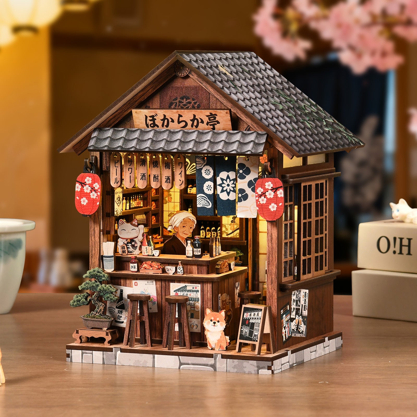 Miniature wooden pub book nook house with lit interior, porch bench, and cat figurine