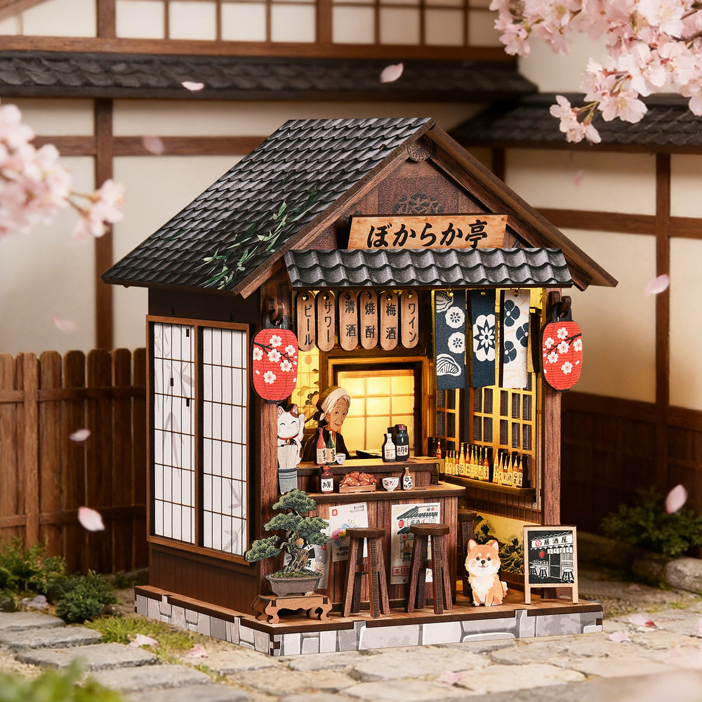 Miniature wooden pub book nook house with tiled roof, lantern glow, and cat figurine