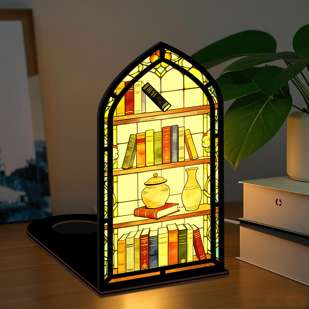 Arched illuminated book nook with faux books, teapot, and vase on a warm-lit stand.