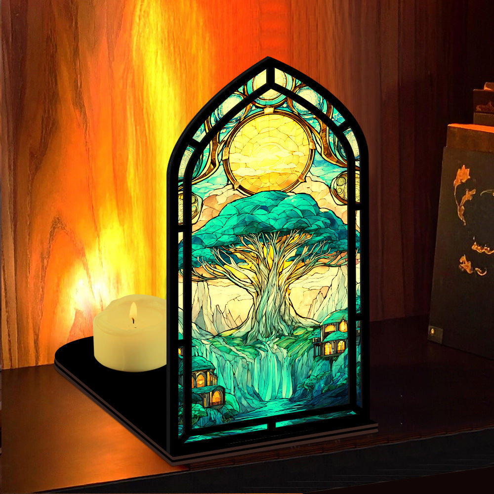 Tree-of-life book nook display with arched stained-glass tree artwork and two lit candles