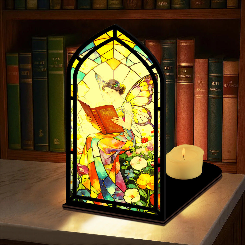 Stained glass fairy book nook with arched reading panel, black frame, small candle on base