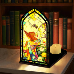 Stained glass fairy book nook with arched reading panel, black frame, small candle on base