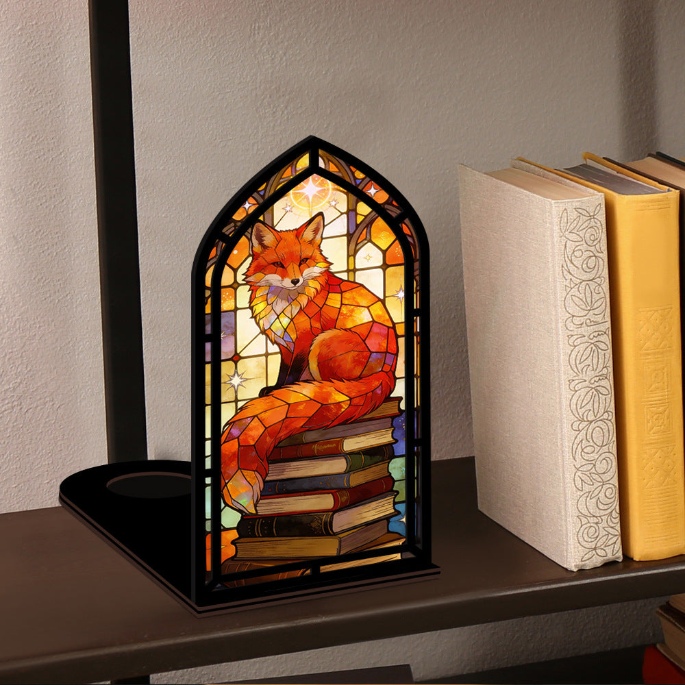 Compact arched stained-glass fox book nook with stacked books and warm light